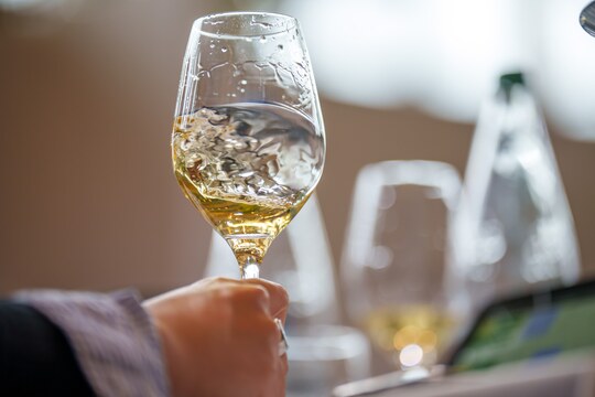 Verre avec vin blanc en mouvement Verre avec vin blanc en mouvement